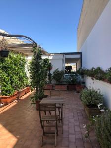 um pátio com uma mesa de madeira e algumas plantas em Visa Residence em Bari