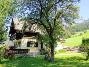 uma casa com uma árvore em frente em Ferienhaus Anke - Ausseerland Salzkammergut em Pichl bei Aussee