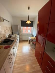 una cucina con armadi rossi e pavimenti in legno di Messe zu Fuß ad Hannover