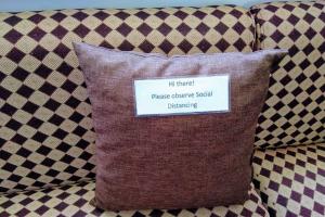 a pillow with a sign on it sitting on a couch at Monallan Boracay Hotel in Boracay
