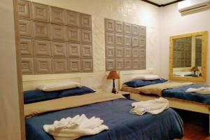 1 dormitorio con 2 camas y espejo en Monallan Boracay Hotel en Boracay