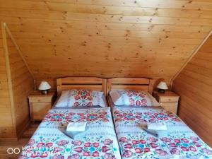 two beds in a room with wooden walls at Drevenica pod Horou in Vyšná Korňa