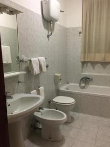 La salle de bains est pourvue de toilettes, d'un lavabo et d'une baignoire. dans l'établissement Hotel PINO LORICATO, à Castelluccio Inferiore