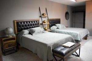 Un dormitorio con 2 camas y un banco. en Hotel Diez, en Celaya