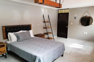 1 dormitorio con cama, escalera y espejo en Hotel Diez, en Celaya