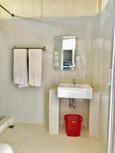 a bathroom with a sink and a mirror and towels at Penginapan Intan Bandara in Duku