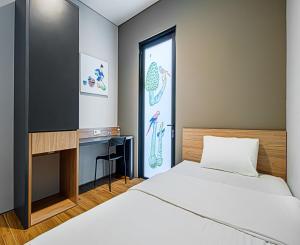a bedroom with two beds and a desk and a window at M Studio Karawaci in Tangerang
