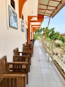 une rangée de bancs sur un bâtiment avec un parapluie dans l'établissement Penginapan Intan Bandara, à Duku