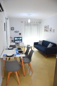 a living room with a table and chairs and a couch at Click Apartments - Tirana in Tirana