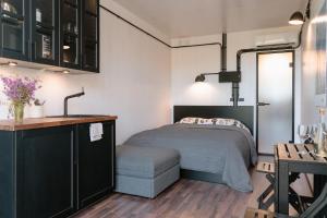 1 dormitorio pequeño con 1 cama y cocina en Unique Tiny House getaway in the nature - Kenshó en Puugi