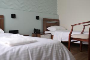 um quarto de hotel com duas camas e uma cadeira em EP Boutique Hotel em Vladivostok