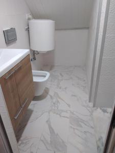 Baño blanco con aseo y lavamanos en Casa Dos Cedros en Setúbal