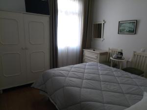 een slaapkamer met een bed, een dressoir en een raam bij Pensao Residencial Vila Teresinha in Funchal