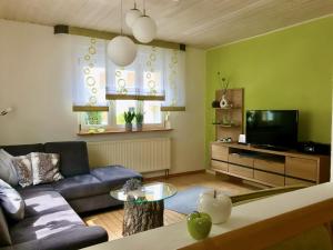 a living room with a couch and a tv at Ferienhaus 2 An der Rodach in Steinwiesen