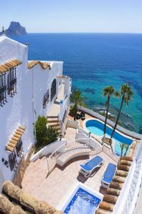 an external view of a villa with a swimming pool and the ocean at Villa Primera Linea in Calpe