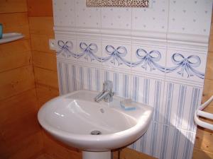 a white sink in a bathroom with a wall at Au Hameau des Sources in Soultzmatt