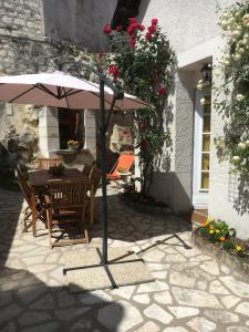 a patio with an umbrella and a table and chairs at les mésanges in Bourré