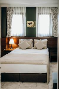Mandalin Pansiyon في سيغاجيك: غرفة نوم بسرير كبير مع نافذتين