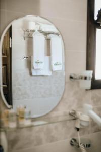 a mirror in a bathroom with towels at Mandalin Pansiyon in Siğacık