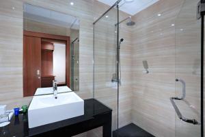 un bagno con lavandino e doccia in vetro di Aston Inn Gideon Batam a Nagoya
