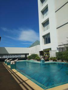 un hotel con piscina di fronte a un edificio di The City Hotel Sriracha by BBH Japan a Si Racha