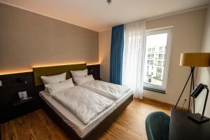 Postel nebo postele na pokoji v ubytování EINSTEIN Hotel am Römerpark + 37 fotografií