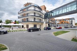 a parking lot with cars parked in front of a building at Apartamenty Bel Mare SeaView by Rent like home in Międzyzdroje