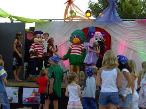 un gruppo di bambini in piedi attorno a un palco con le mascotte di MOBIL HOME 3ch 2sdb A LATTES a Lattes Altre 19 foto