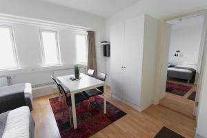 een woonkamer met een tafel en een slaapkamer bij Slagsta Gate Hotell in Norsborg