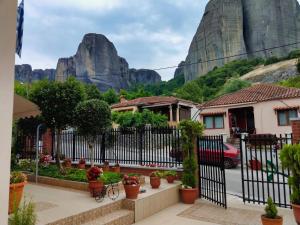 a house with a fence with a mountain in the background at Mama's Cozy Room 2 in Kalabaka