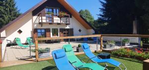 a house with blue chairs in the yard at Apartmány Chalupa "Pod lípou" in Staré Město