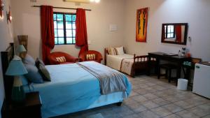 a bedroom with a bed and a table and a desk at Parkers Cottages in St Lucia