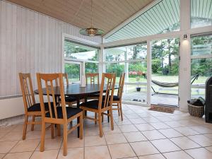 6 person holiday home in Pr st في براستو: غرفة طعام مع طاولة وكراسي ونوافذ