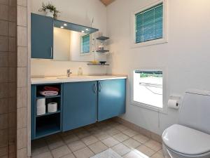 y baño con lavabo azul y aseo. en 6 person holiday home in Pr st en Præstø