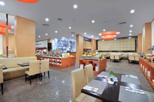 a dining room with tables and chairs in a restaurant at ASTON Inn Gideon Batam in Nagoya