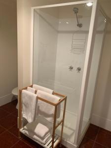 a bathroom with a shower with towels on a shelf at Church Street Villas in Stanley