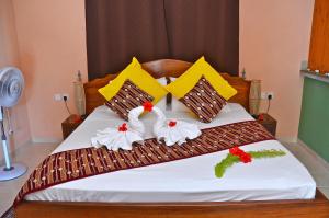 a bedroom with a bed with two swans on it at My Angel in La Digue