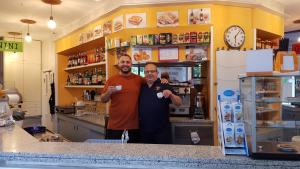 two men standing behind a counter in a store at Locanda Diana in Iseo