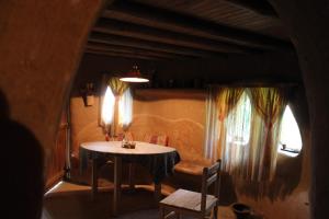 Pokój ze stołem, krzesłami i oknem w obiekcie The Clay House w mieście Leshten