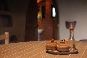 stół z butelką i dwie miski w obiekcie The Clay House w mieście Leshten