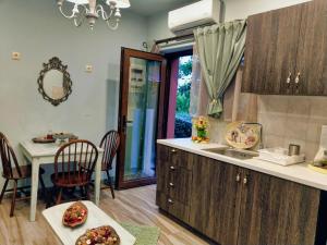 eine Küche mit einem Waschbecken und einem Tisch mit Stühlen in der Unterkunft Mama's Cozy Room 2 in Kalambaka