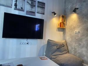salon z telewizorem i krzesłem w obiekcie LA CUEVA DEL LOCO, Bretones 29 w mieście Sanlúcar de Barrameda