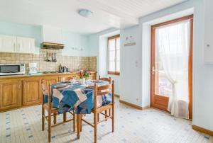 a kitchen with a table and chairs in a kitchen at Bocage in Cersay