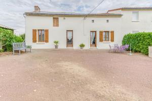 une maison blanche avec deux chaises et un banc dans l'établissement Bocage, à Cersay