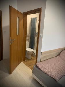 drzwi do łazienki z toaletą i łóżkiem w obiekcie Hostel Sportowa w mieście Płońsk