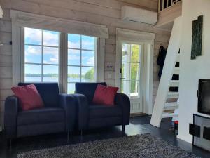 a living room with a couch and large windows at Sammalkalliontie 83 Lodge in Kinnula