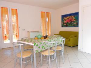 cocina con mesa con sillas y sofá en Villa Ca' Claudia, en Rosolina Mare