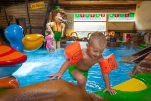 un joven jugando en una piscina en Oostappen Vakantiepark De Berckt BV, en Baarlo