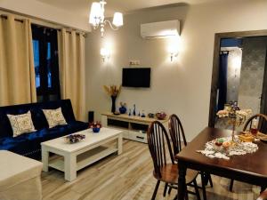 Una sala de estar con un sofá azul y una mesa. en Mama's Cozy Room 3, en Kalambaka