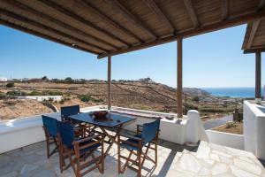 a patio with a table and chairs and the ocean at A&A House Mykonos A in Ano Mera